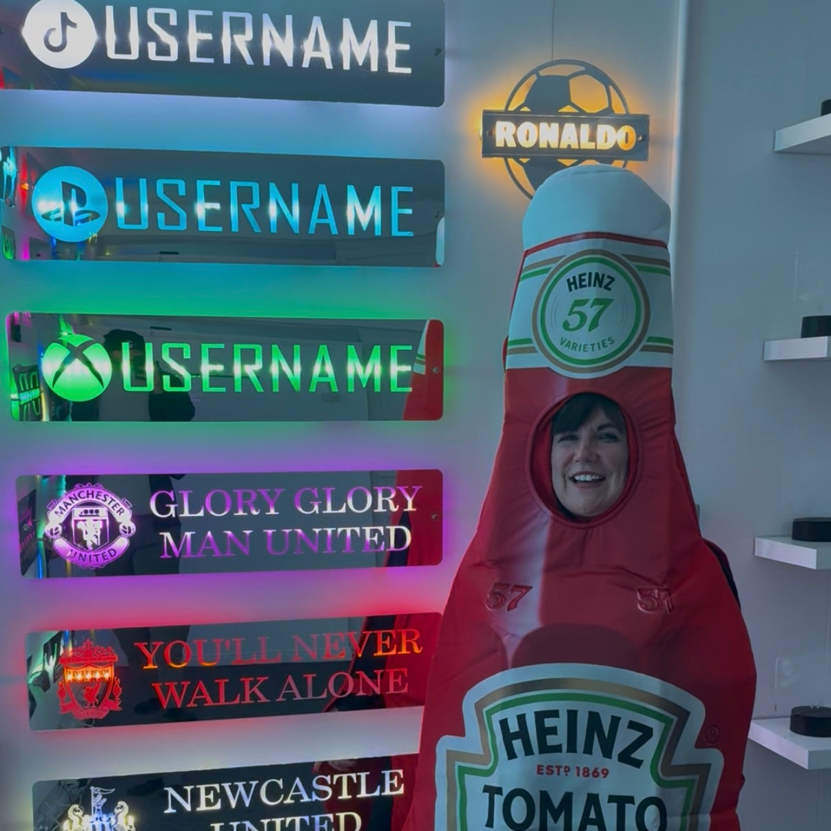 Mum posing in a giant Heinz bottle costume by the neon signs